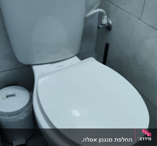 אסלה עם חיבורי צנרת ומיכל הדחה
